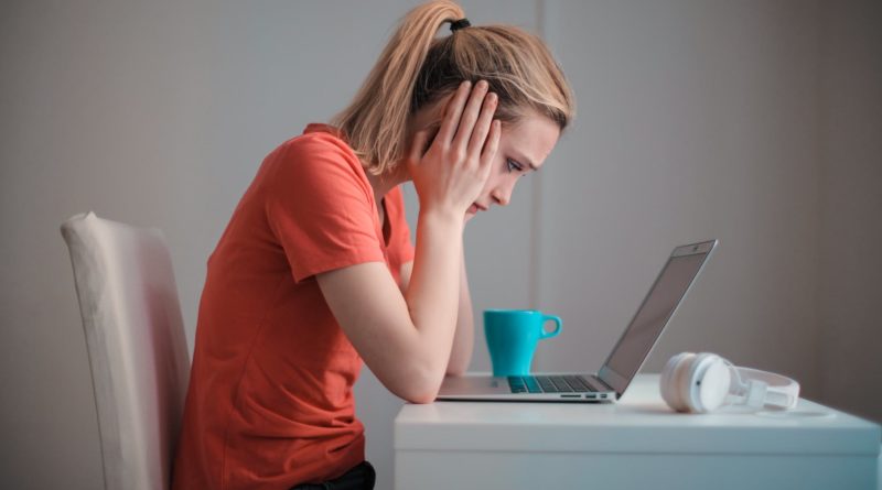 young troubled woman using laptop at home