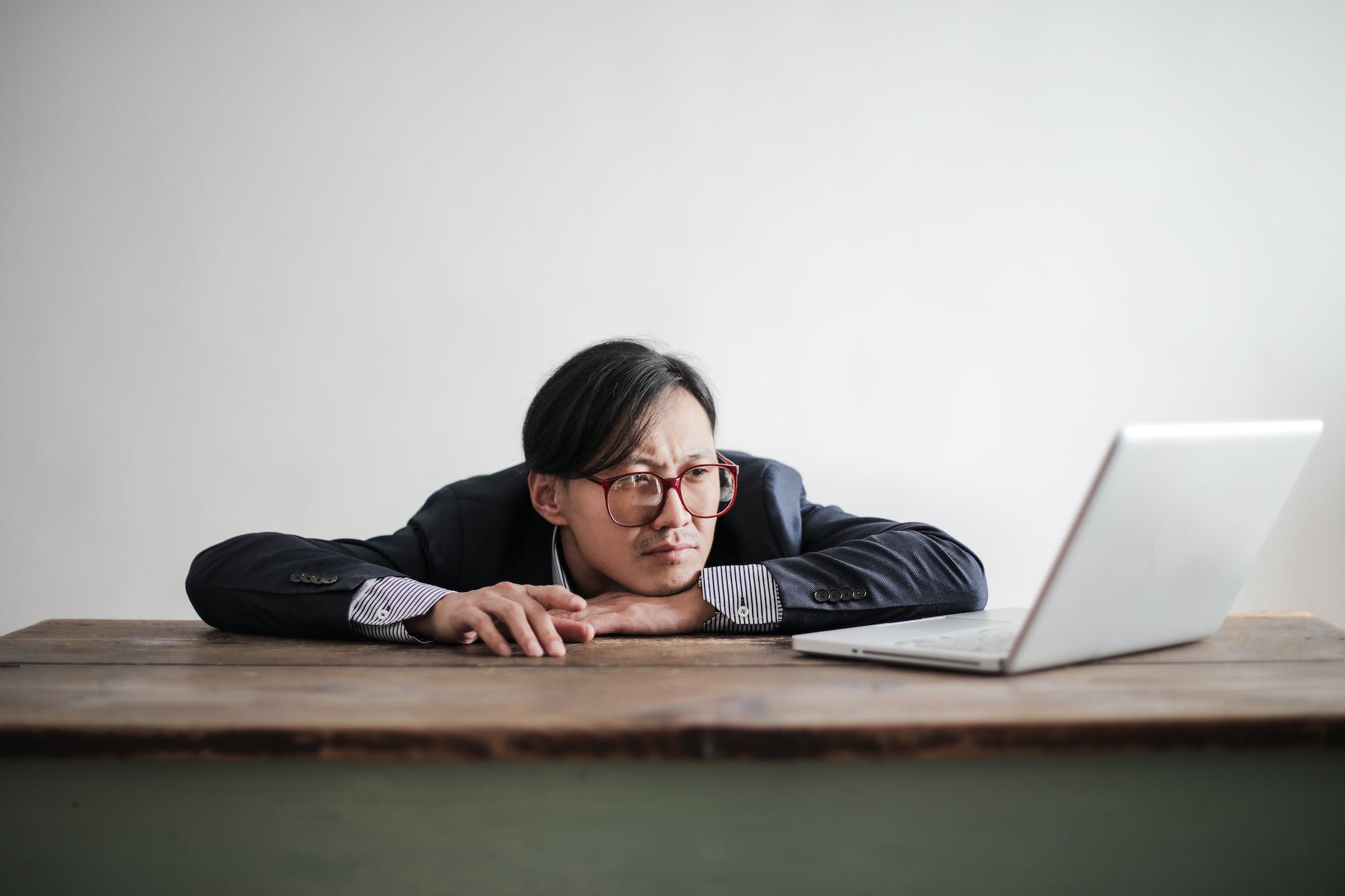 bored formal man watching laptop at desk